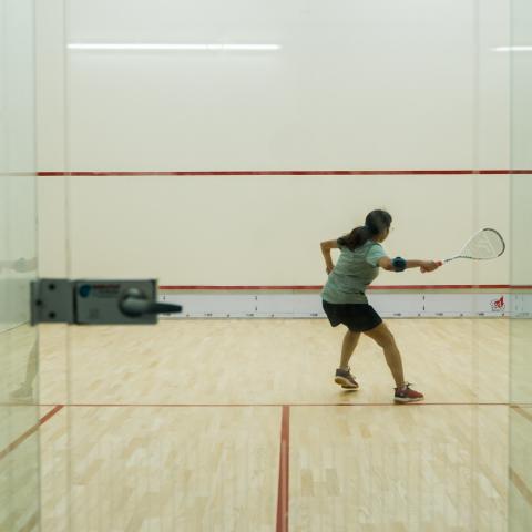 A student playing squash