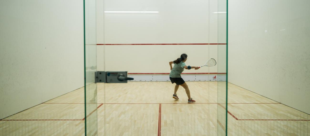 A student playing squash