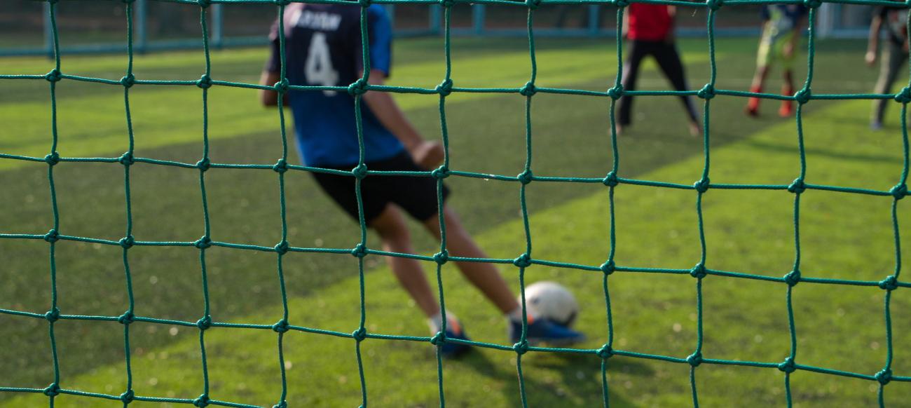 A student playing football on football turf