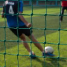 A student playing football on football turf